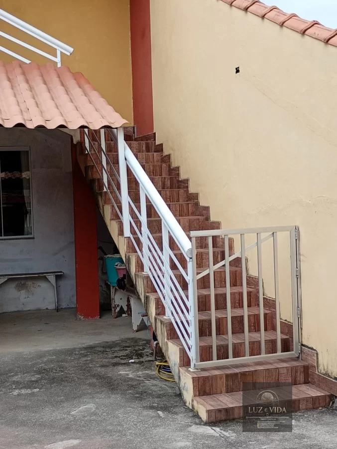 Casa de 2 andares com um imóvel em construção na frente